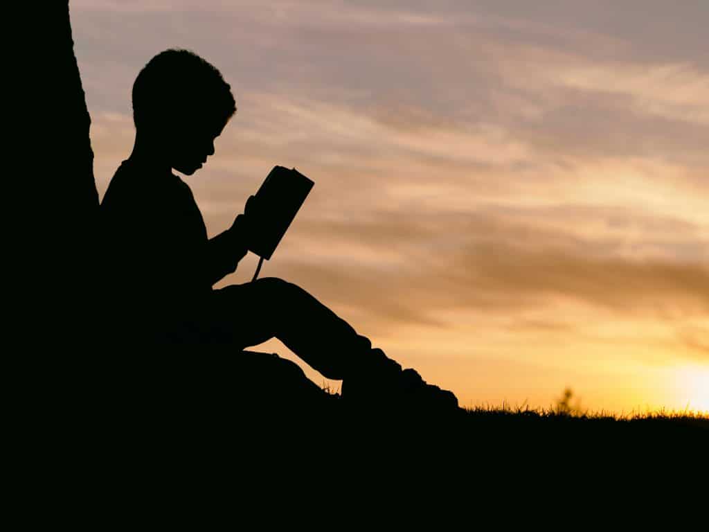 child reading by tree