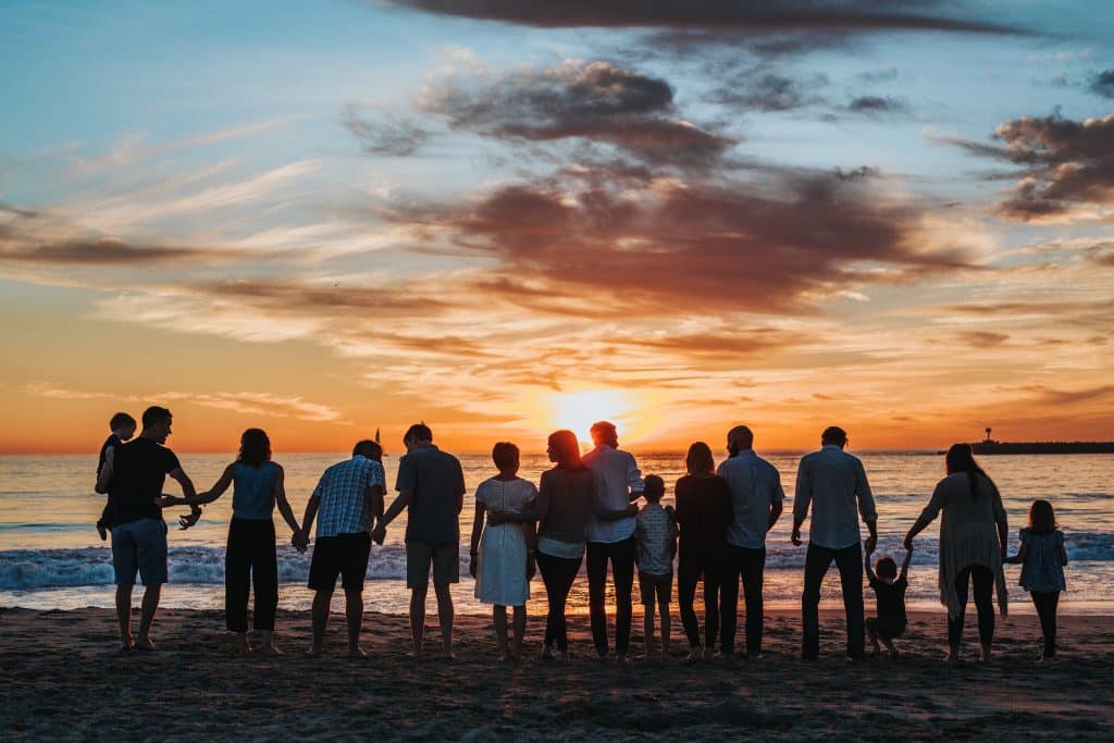 family standing at sunset