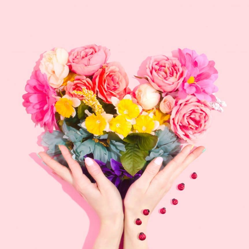 hands holding heart of flowers