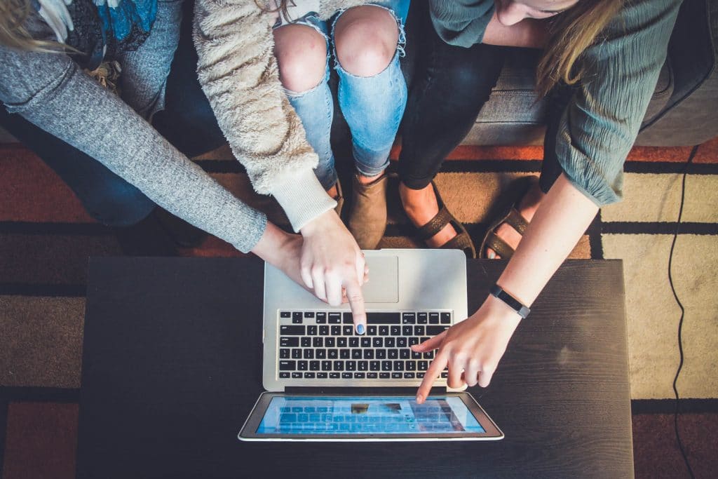 people pointing at laptop