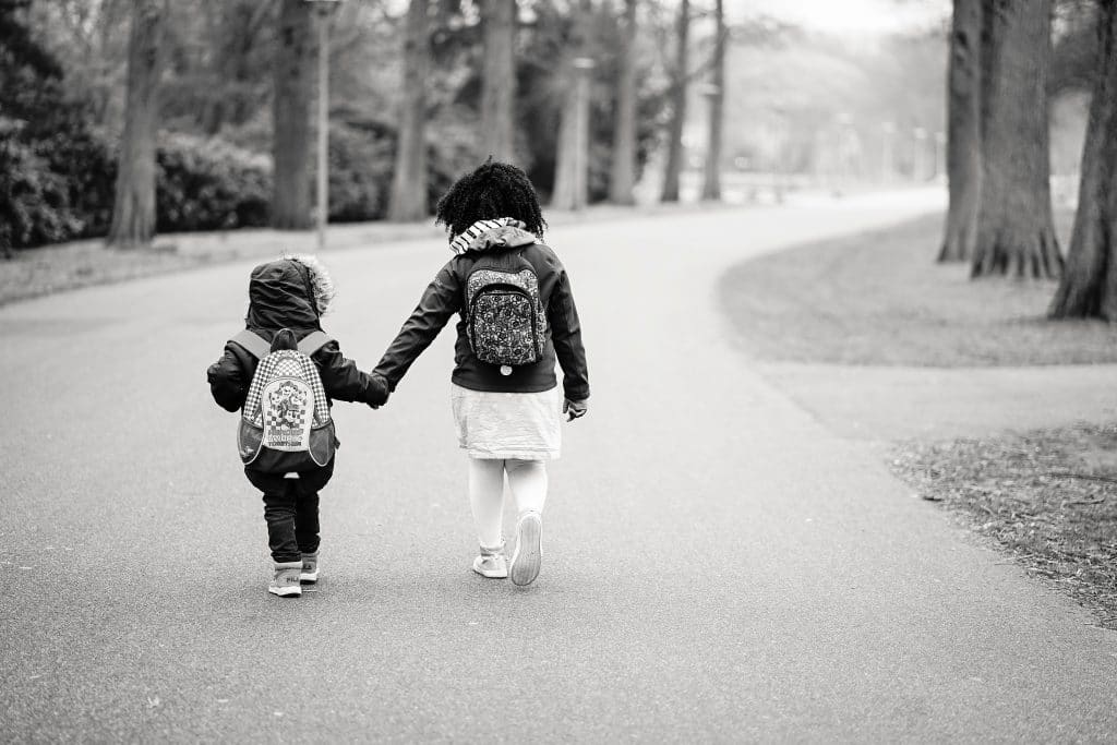 two children walking on road