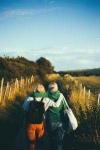 two women walking embracing