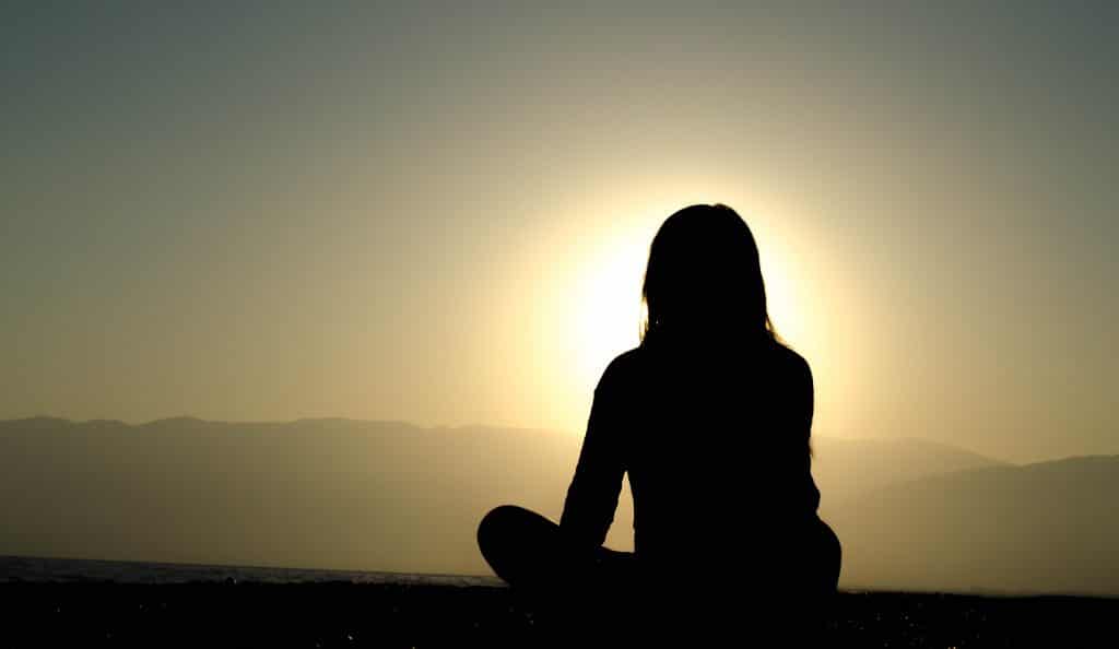 woman meditating sun