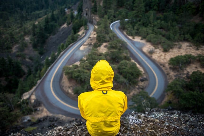 yellow coat looking at road